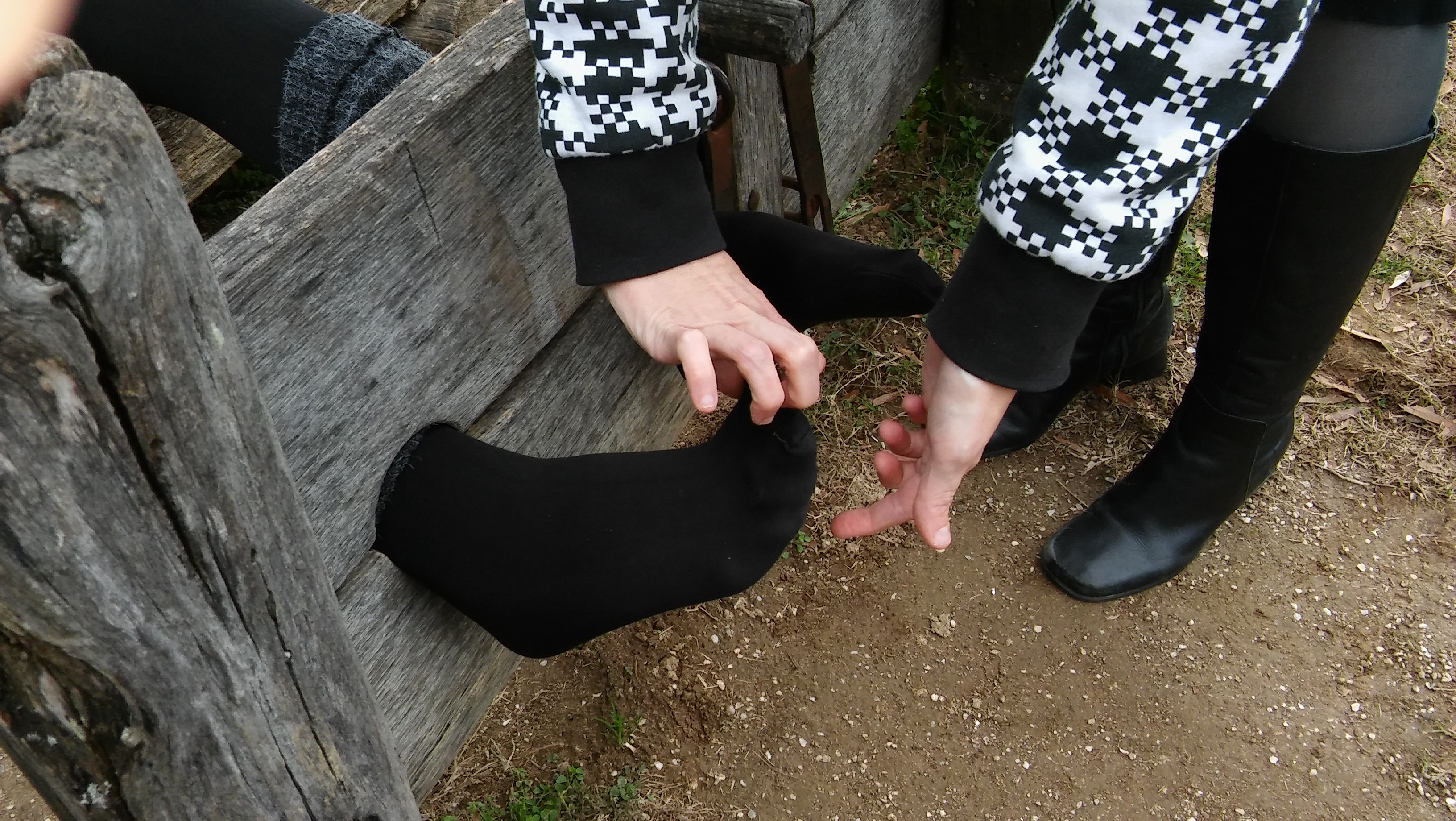 Tickling on black tights in the stocks