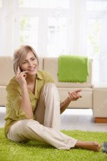 7257552-Cheerful-woman-speaking-on-mobile-phone-sitting-on-living-room-floor-gesturing-with-hand.jpg