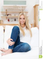 smiling-beautiful-young-woman-jeans-happy-sitting-barefoot-sofa-indoors-camera-34268921.jpg