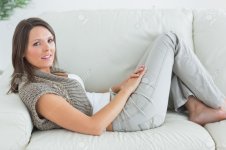 16054166-Happy-woman-relaxing-on-sofa-at-home-Stock-Photo-feet.jpg