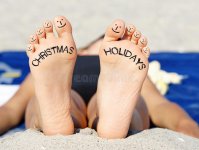 christmas-holidays-beach-closeup-feet-toes-text-upper-case-text-inscribed-soles-funny-face-drawn.jpg
