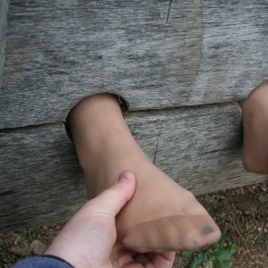 Tickling feet in pantyhose locked in stocks