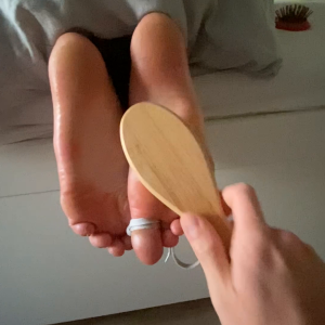Feet tickling with brush